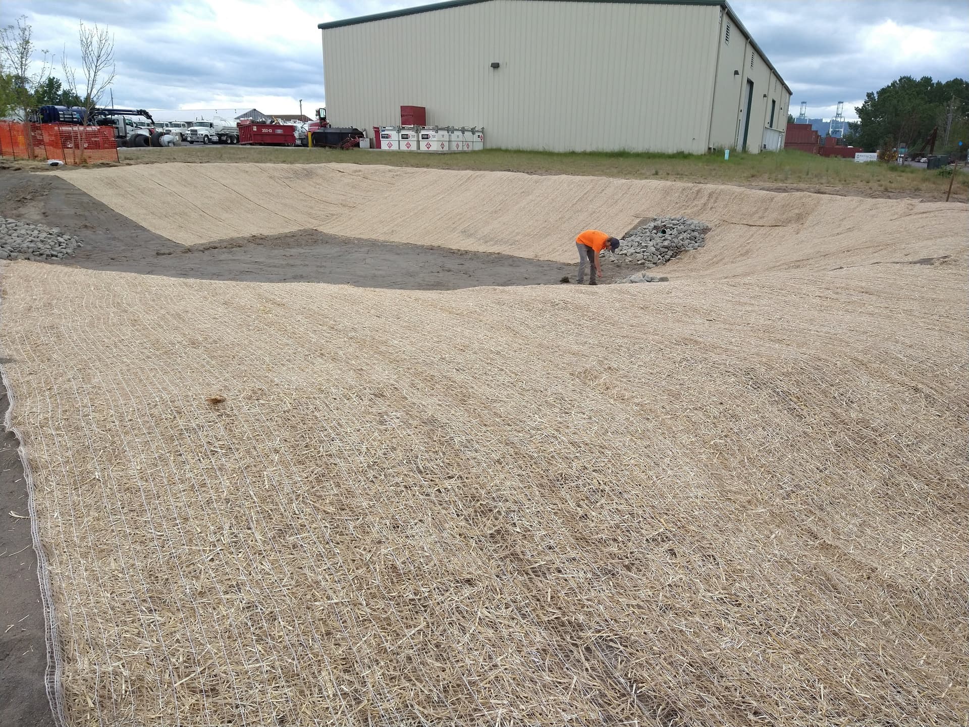 Erosion control blankets installed on large basin with rock energy dissipator