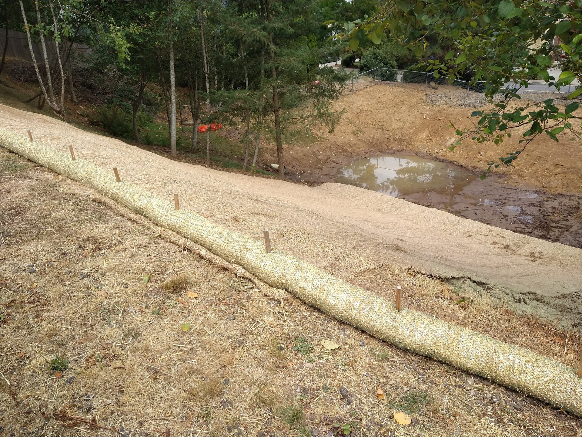 Wider view of erosion control blanket installation on slope