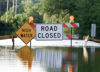 Flooded road with High Water and Road Closed signs